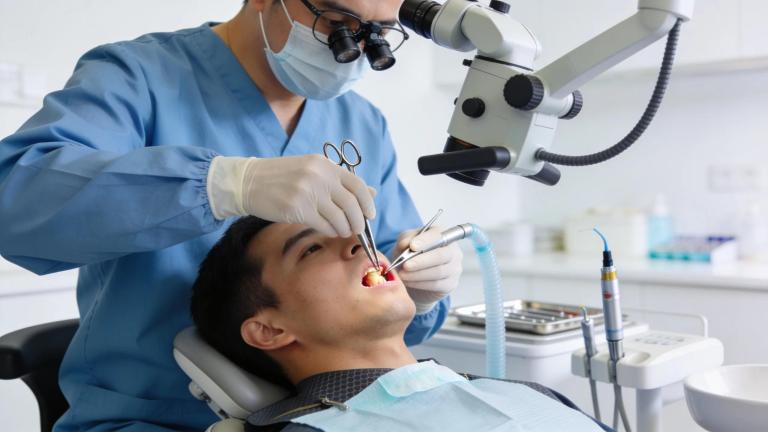 Dental professional performing an apicoectomy procedure with advanced tools in a modern office