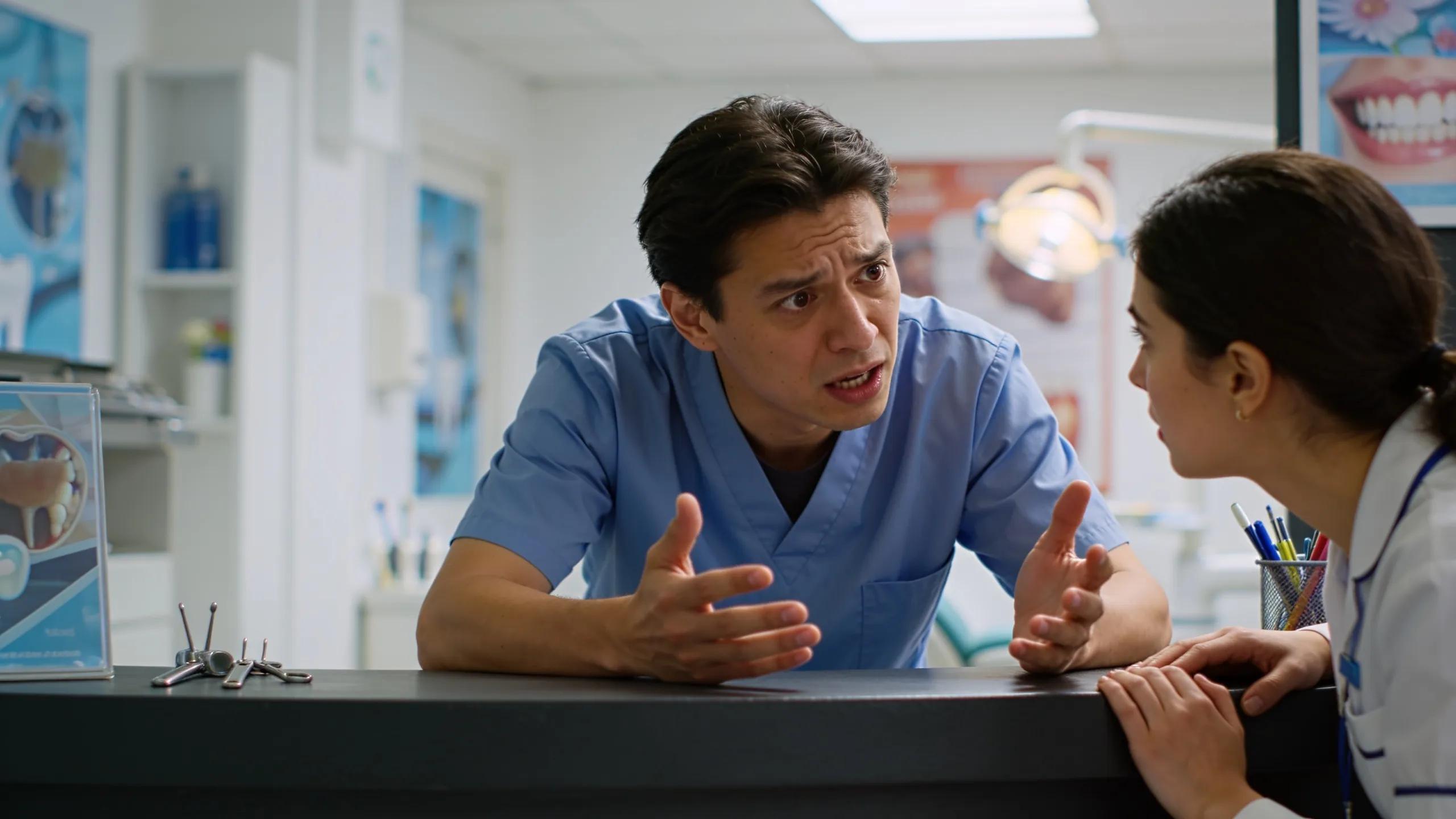 Patient discussing urgent dental issues with a staff member in a clinic, emphasizing emergency care